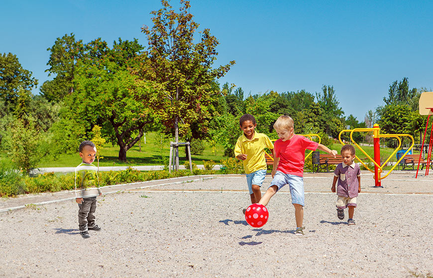 Photo of kids playing with a ball in a park