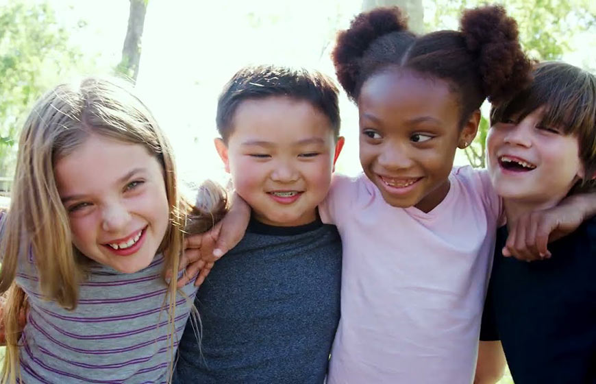 Photo of happy kids with their arms around each others shoulders